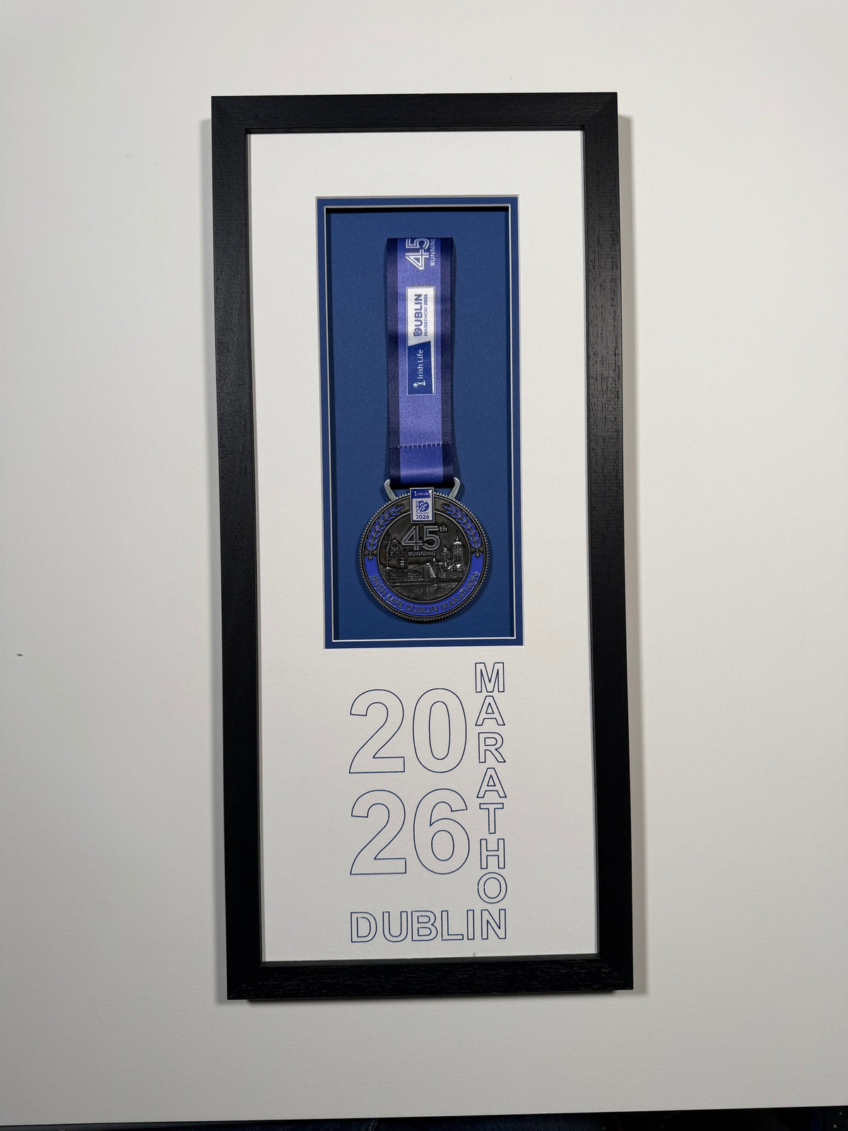 Dublin Marathon 2026 medal and ribbon in a black frame with a blue inner mount and 2026 Dublin Marathon lettering, by Phoenix Framers, Sandymount