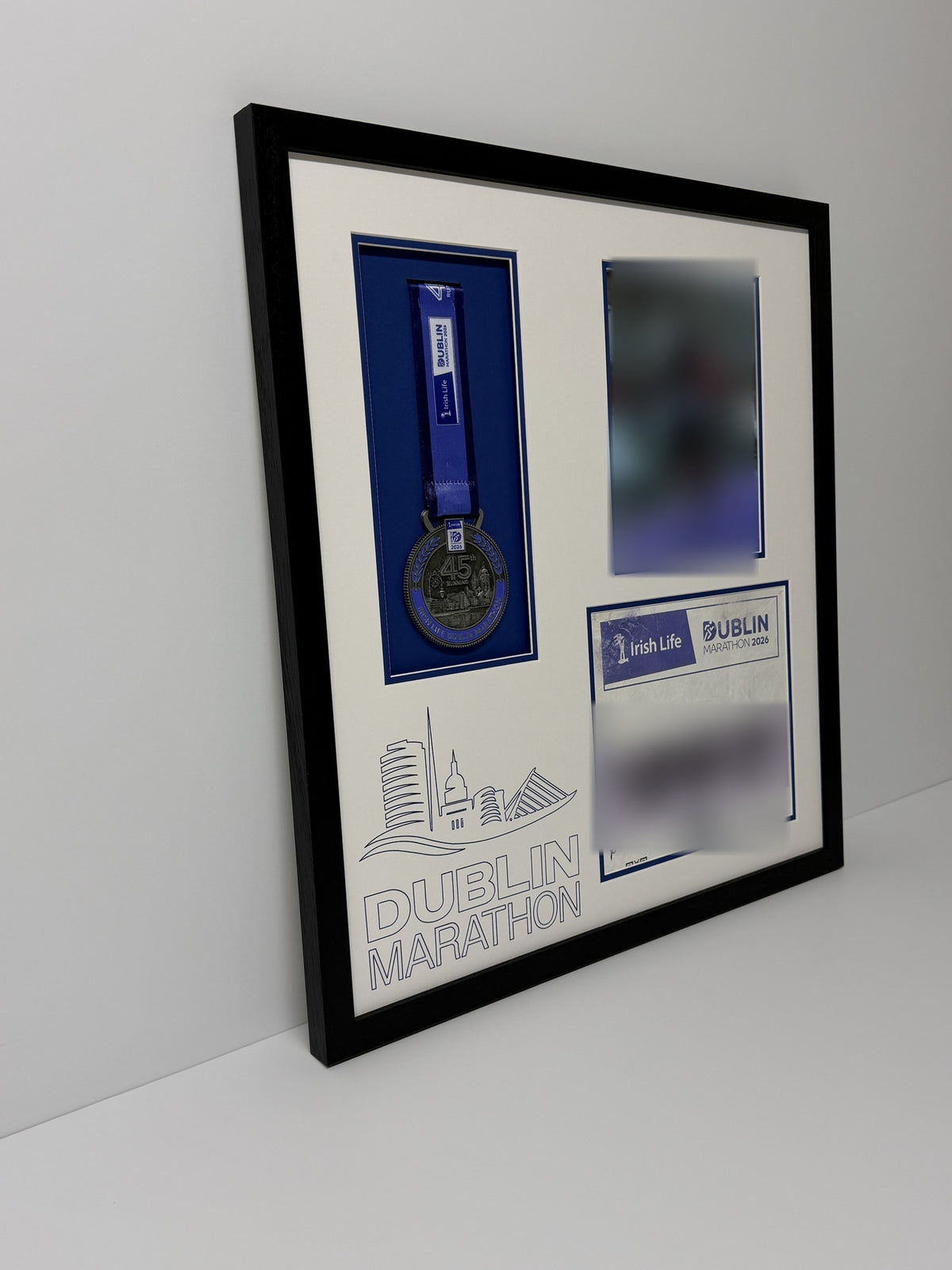 Medal, bib and photo frame leaning against a wall